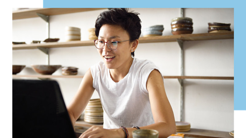 A person with glasses looking at a laptop