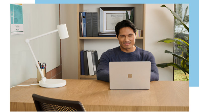A person is using a laptop at a desk in an office.