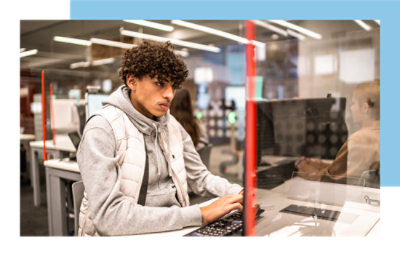 A person typing on a keyboard in a cubicle