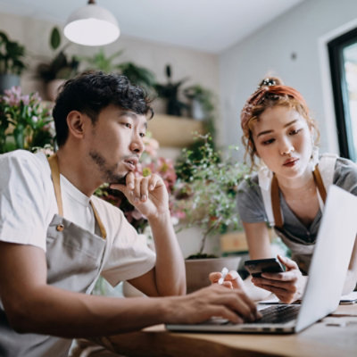 Seorang pria dan wanita bekerja di depan laptop