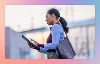 Seorang perempuan membawa tas dan bekerja menggunakan tablet.