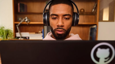 Persoon met koptelefoon kijkt naar monitor