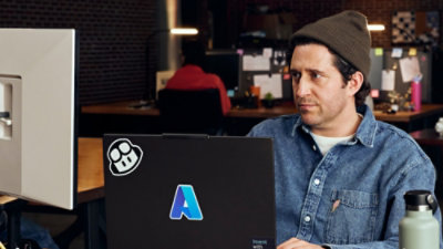 Een persoon die naar een laptop kijkt.