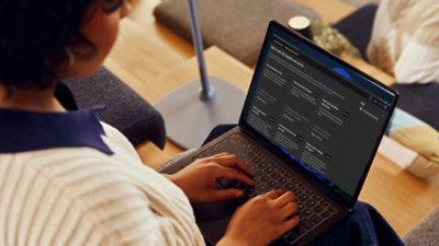 Een persoon die naar een laptop kijkt.