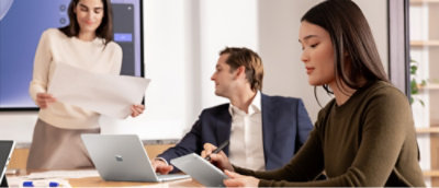 Three people in a meeting room.