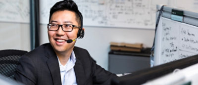 A man wearing headphones and smiling.