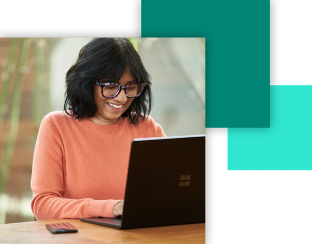 A smiling woman having a laptop in a table