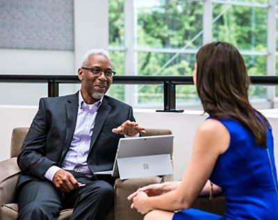 Two people sitting in an office environment and discussing