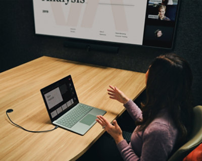 A woman sitting at a desk using a laptop.