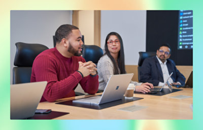 A group of people talking with eatch other in a meeting room.