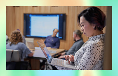 A women working with a laptop with office flokes.