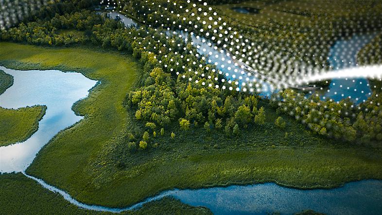 Vue aérienne d’un terrain boisé dans lequel serpente une rivière.