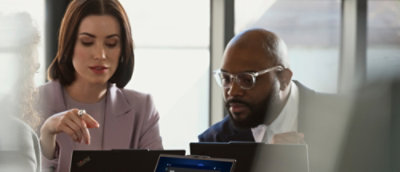 A man and woman looking at a laptop.