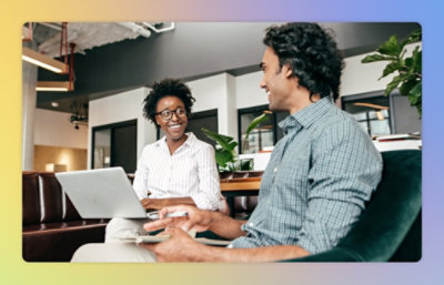A man and woman looking at a laptop.