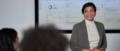 A woman is giving a presentation to a group of people.