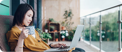 A woman with curly hair sitting at a desk using a computer.