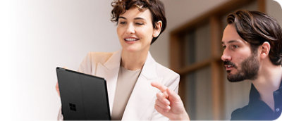 A woman explaining something on a tablet to a man.