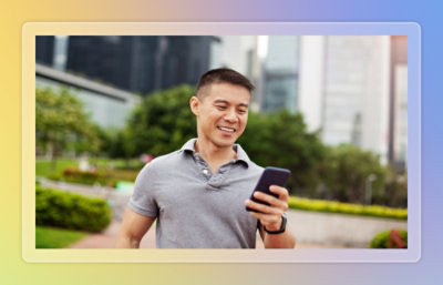 Person checking a smartphone in an urban walkway.