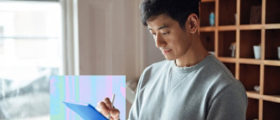 Person using a tablet with a stylus in a home workspace.