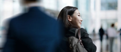 Person with a backpack walking through a modern office lobby.