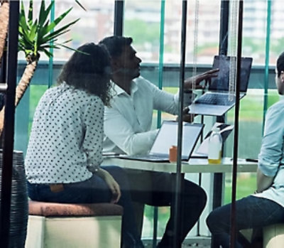 A group of people sitting at a table with a laptop.