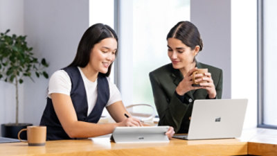 A couple of women looking at a laptop.