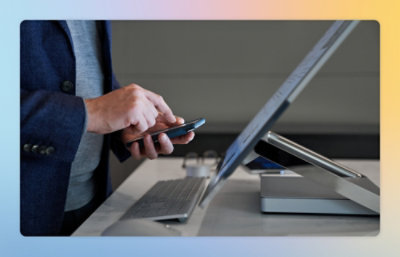 A person using a phone and a computer.