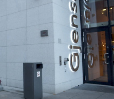 A building with glass doors and light reflecting on them.