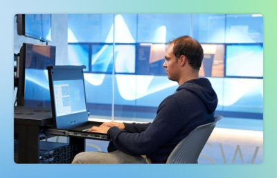 A person sitting at a desk using a laptop.