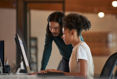 A woman sitting at a table using a laptop.