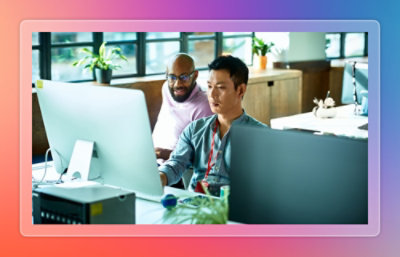 People working on a desktop together.