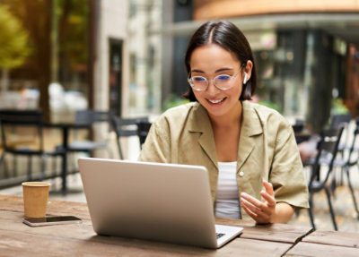 Person using a laptop at an outdoor café table