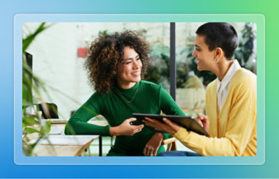 Two women are looking at a tablet.