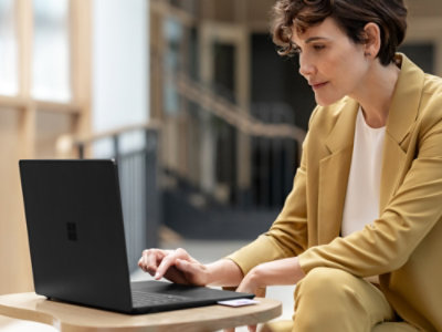 A woman sitting at a table using a laptop.