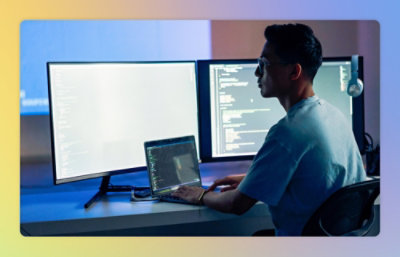 A man sitting at a desk using a laptop.