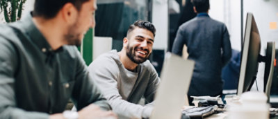A man smiling at a computer.
