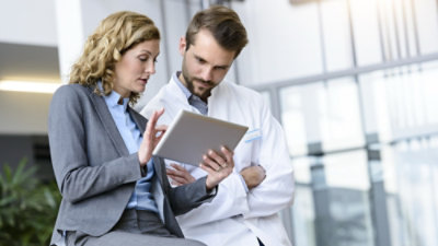 A man and woman looking at a tablet.