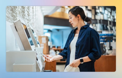 A woman in a blue shirt standing in a store with a row of white rectangular objects visible.