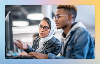 A man and woman looking at a computer screen.