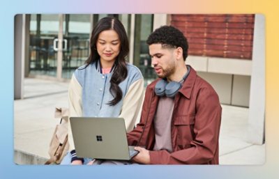A man and woman looking at a laptop.