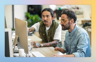 A group of people gathered around a computer.