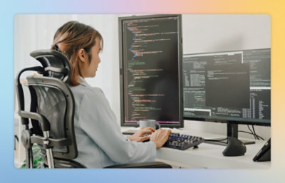 A person sitting at a desk with a computer screen displaying text.