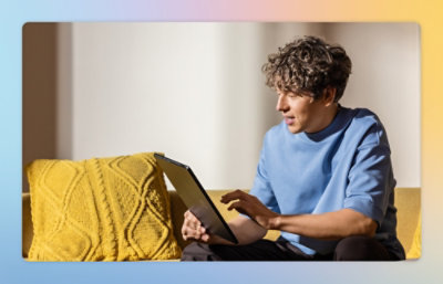 A person sitting on a couch using a laptop.