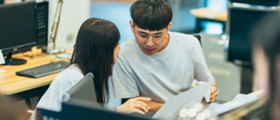 A man and a woman discussing while looking at the laptop