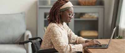 A woman sitting at a table using a laptop.