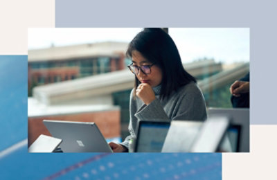 Osoba koja radi na laptopu u zatvorenom prostoru sa drugim uređajima vidljivim u prvom planu.