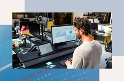 Osoba koja sedi za stolom i gleda u ekran stonog računara.