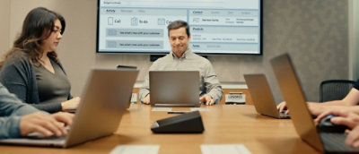 Team meeting with laptops around a conference table.