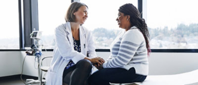 Doctor and patient holding hands at bedside