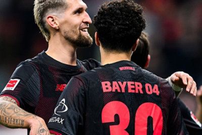 A group of men wearing sports uniforms, with visible text reading BAYER 04 MEDAX on a jersey.